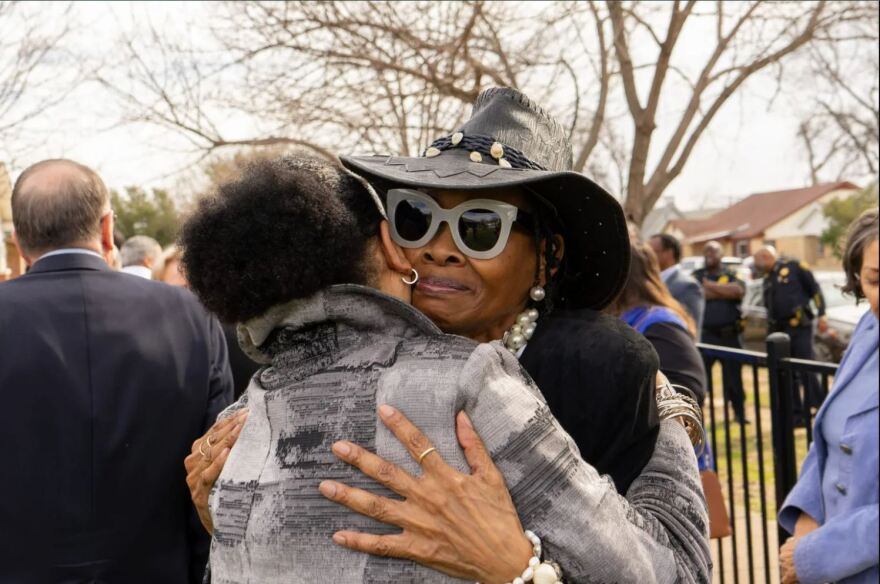 Sandy Joyce embracing a friend at the opening of the Renaissance House